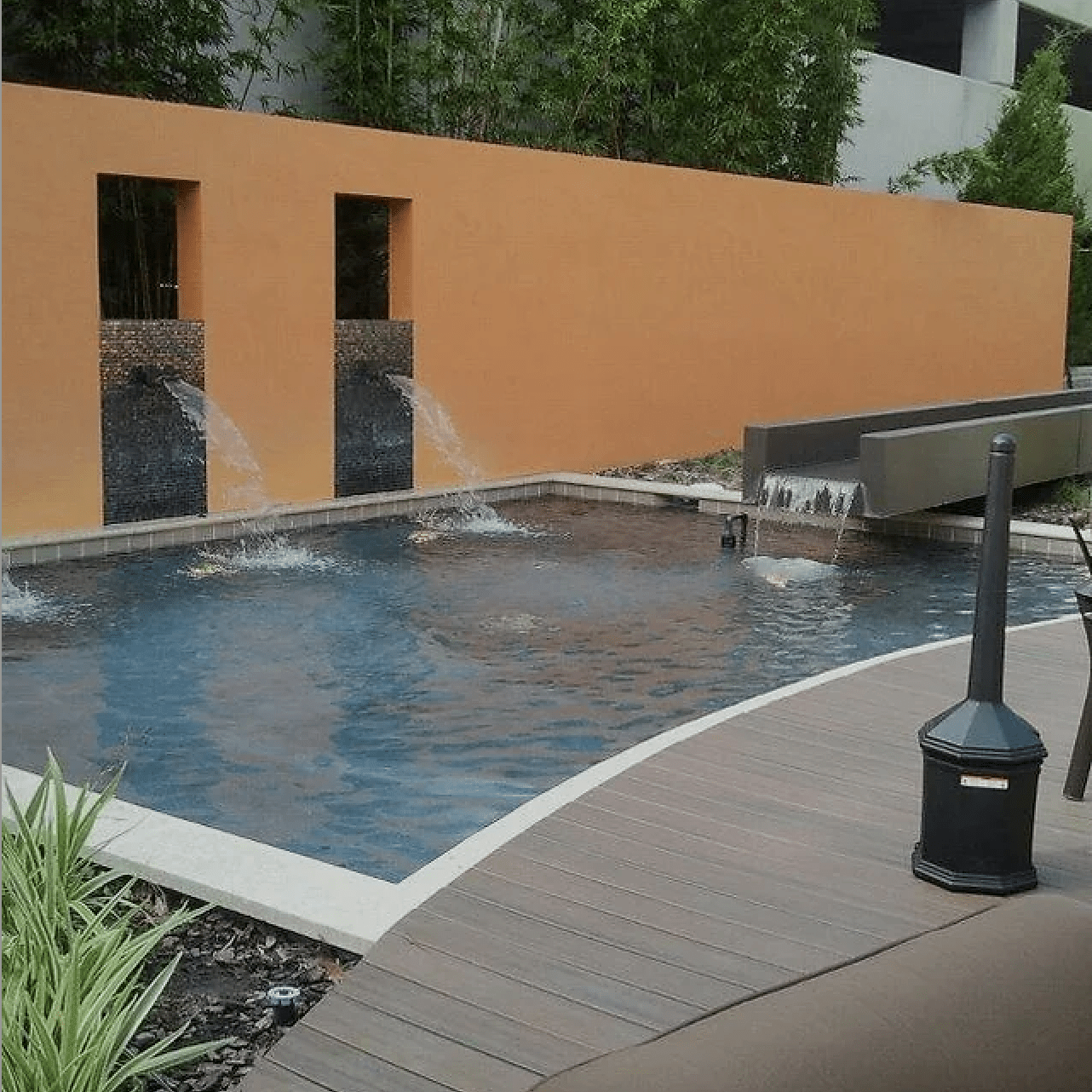 orange wall with two fountains pouring into a pool